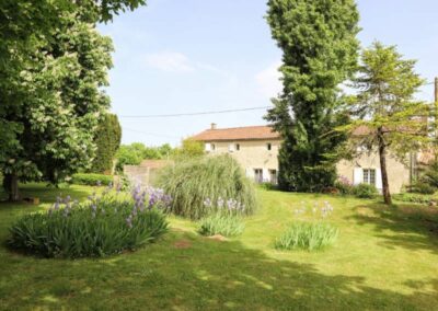 Espace verdoyant bordant le terrain de tennis des Gîtes de Chavigny.