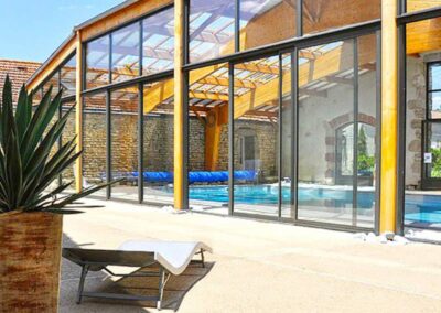 Piscine intérieure avec toiture vitrée laissant entrer une lumière naturelle agréable.