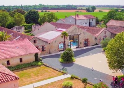 Photo vue du ciel du domaine des Gîtes de Chavigny à Sainte-Gemme-la-Plaine, avec piscine et espaces verts.