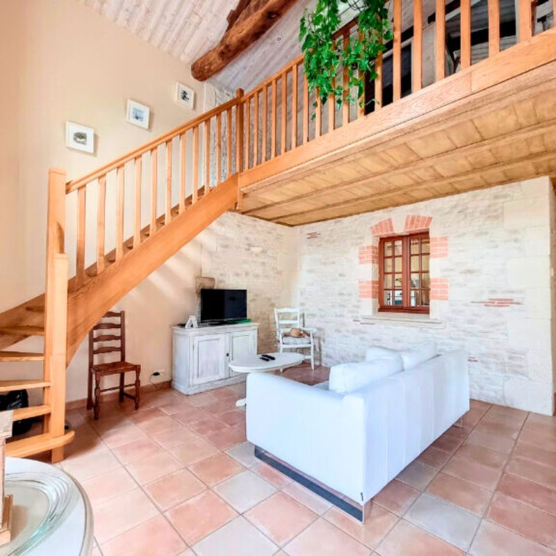 gite 4 personne du domaine de Chavigny en Vendée Salon cosy avec murs en pierre et canapé blanc au Gîte Le Noisetier